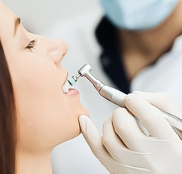 Dentist examining a patient's teeth during a routine dental checkup.