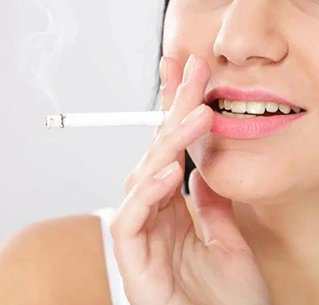 Broken cigarette symbolizing quitting smoking to improve oral health.